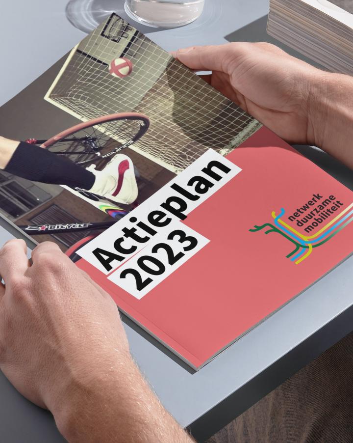 Persoon leest Actieplan 2023 van Netwerk Duurzame Mobiliteit