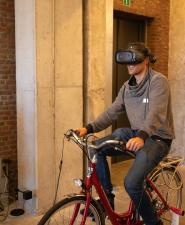 personen proberen fiets met VR-bril uit
